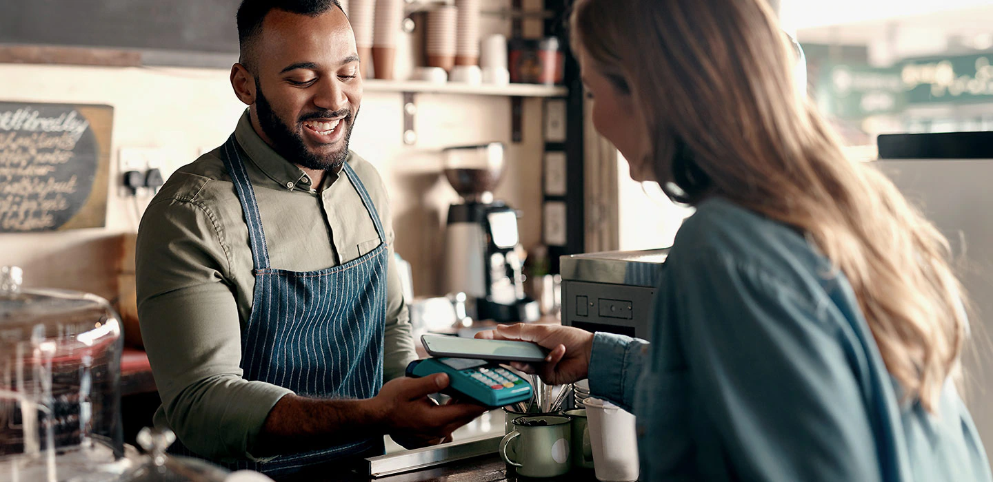 Kvinne som bruker Samsug Pay på cafe